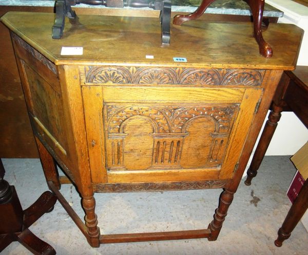 A 17th century style carved oak side cupboard, with canted sides.