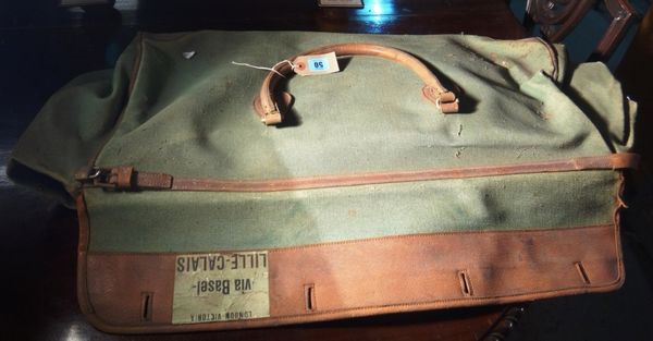 An early 20th century green canvas and brown leather travel bag.