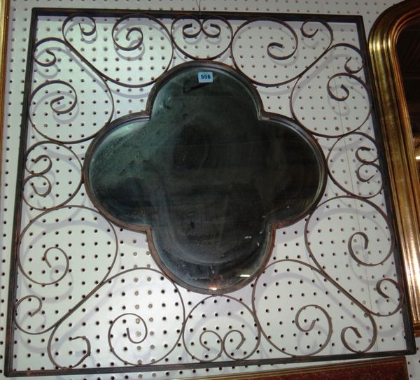 A 20th century metal wall mirror with quatrefoil shaped plate.