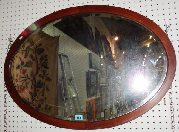 An oval mahogany wall mirror.