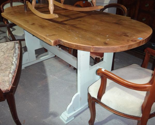 A pine rounded rectangular dining table and a pine bench.