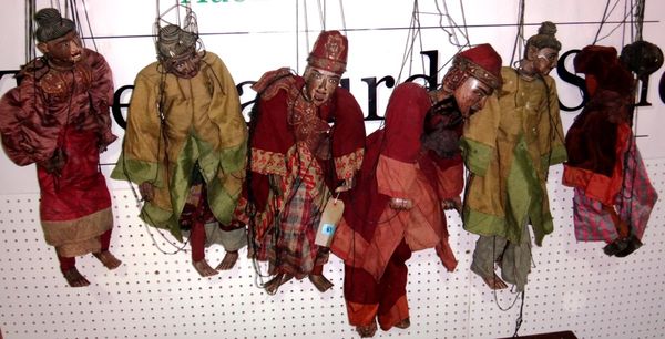 A quantity of Eastern carved puppets.