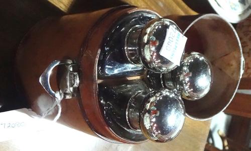 A group of three glass spirit flasks with plated screw caps, of segment form in a tan leather cylindrical case.