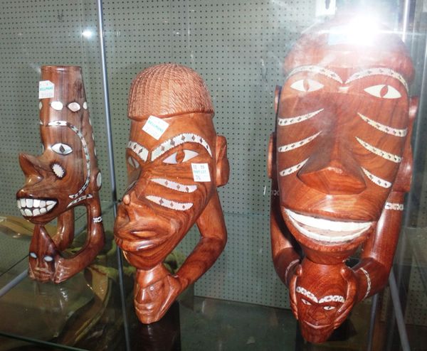 A group of three Solomon Islands carved and inlaid canoe prow figureheads.
