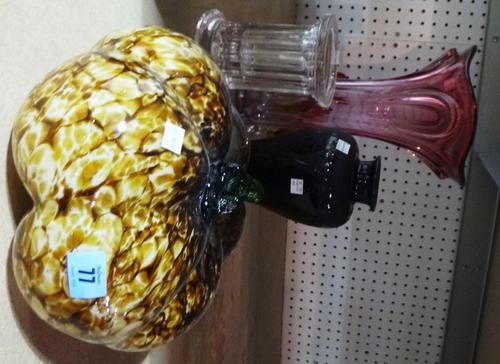 A glass model of a pumpkin and a black glass vase.