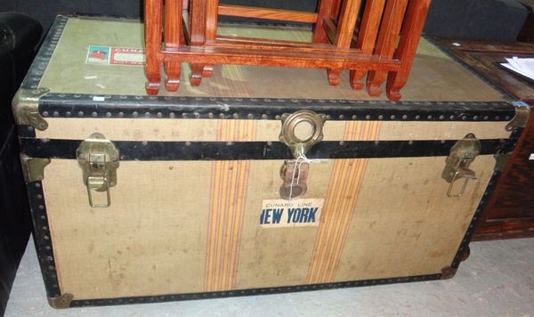 A travel trunk with Cunard baggage labels, containing two bowler hats, a top hat and a Teddy bear.