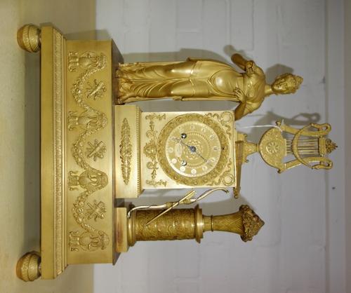 A French gilt bronze figural mantel clock, late 19th century, the indistinctly signed dial flanked by Diana the Huntress and a vase of flowers, raised