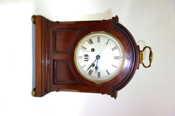 A mahogany cased mantel clock, late 19th century, with brass handle and domed top over a silvered dial and stepped plinth base, on brass bun feet, enc