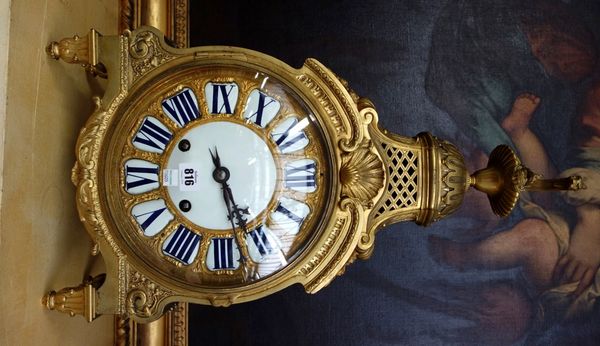 A Louis XIV style ormolu mantel clock, early 20th century, with a Grecian oil lamp finial over a 10 inch white enamel and ormolu embellished dial, on