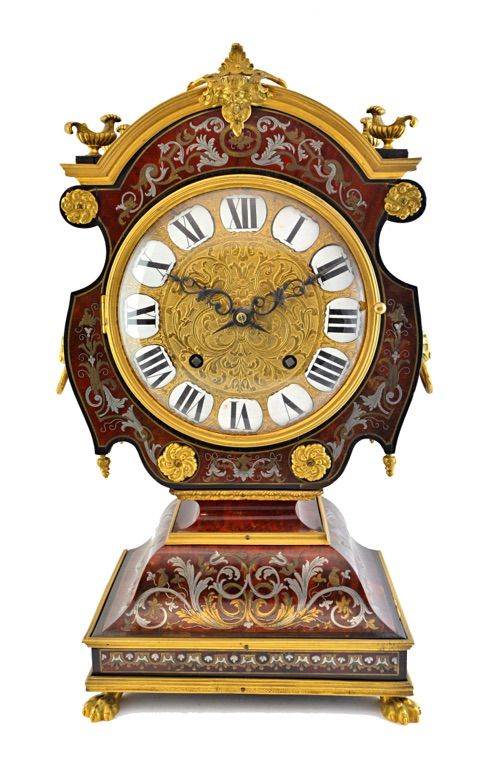 A Louis XIV style ormolu mounted 'tete-de-poupee' mantel clock, 19th century, with a boulle work shaped case with ormolu embellishments, a foliate eng