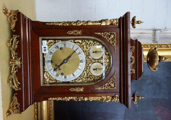 A mahogany cased triple train mantel clock, late 19th/early 20th century, with urn surmount over an ornately ormolu embellished case, the dial with si