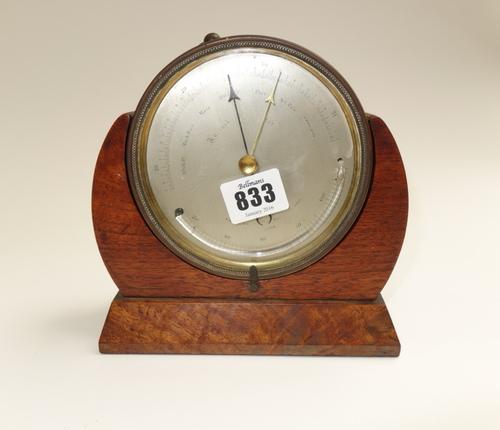 A brass cased table aneroid barometer, presentation engraved to the rear and dated 1862, housed in a mahogany and walnut frame, 12.4cm diameter, toget
