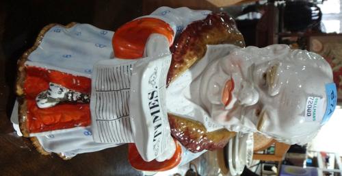 A German porcelain tobacco jar and cover, Conta and Boehme Thuringia, modelled as a gentleman in night robes, reading the 'Times' newspaper.