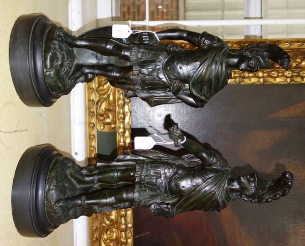 A pair of composite bronze figures, 20th century, each depicting a Roman soldier raised atop a naturalistic base, indistinctly signed, on a black slat