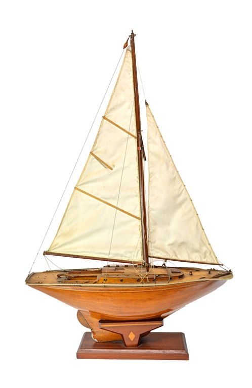 A wooden model sailing boat, naturalistically painted and with a lead keel, on a wooden stand, 65cm wide.  Illustrated