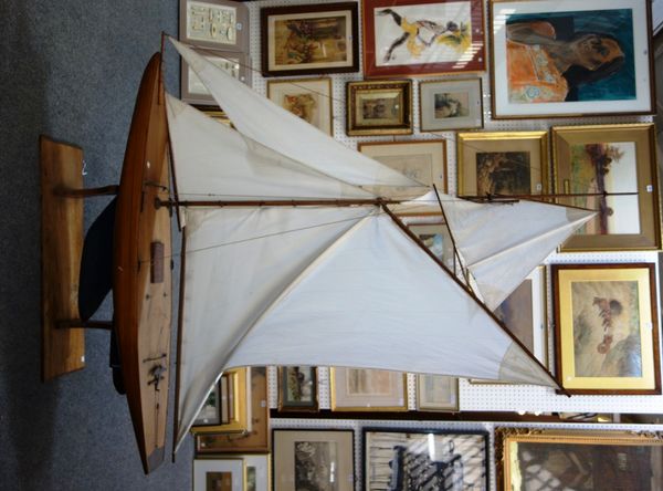 A wooden model sailing boat, with lead lined keel and a metal runner, on a wooden stand, 157cm wide.