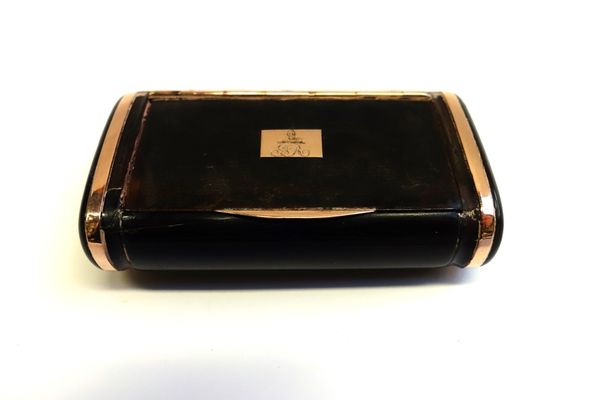 A gold mounted tortoiseshell hinge lidded snuff box, of curved rectangular form, the cover crest and monogram engraved, mid 19th century, length 6cm.