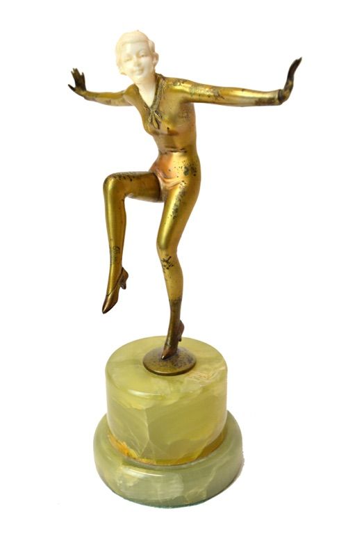 A Lorenzl style Art Deco bronze and ivory figure, modelled and cast with arms outstretched and one leg raised, on a circular onyx plinth (a.f), unsign