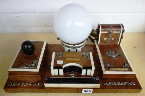 An Art Deco rosewood and ivory strung desk compendium with silver foliate mounts, comprising; a table light with opaque globular shade, a calendar, a