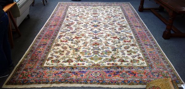A Turkish carpet, the ivory field with a trailing vine of flowers and leaves, pink main border and guard bands, 268cm x 393cm.