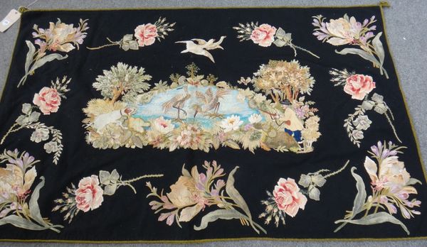 An embroided panel, the black field with a central panel of birds and hunter with his dog, floral spreays, 105cm x 168cm.   Illustrated