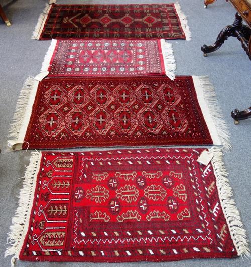 A Beluchistan rug, the madder field with an interconnecting design, 130cm x 80cm, together with an Afghan prayer rug with a madder mehrab and three ho