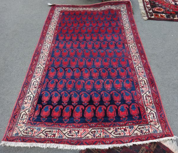A Saraband rug, Persian, the indigo field with rows of madder and indigo botehs, an ivory boteh and vine border, 210cm x 132cm.