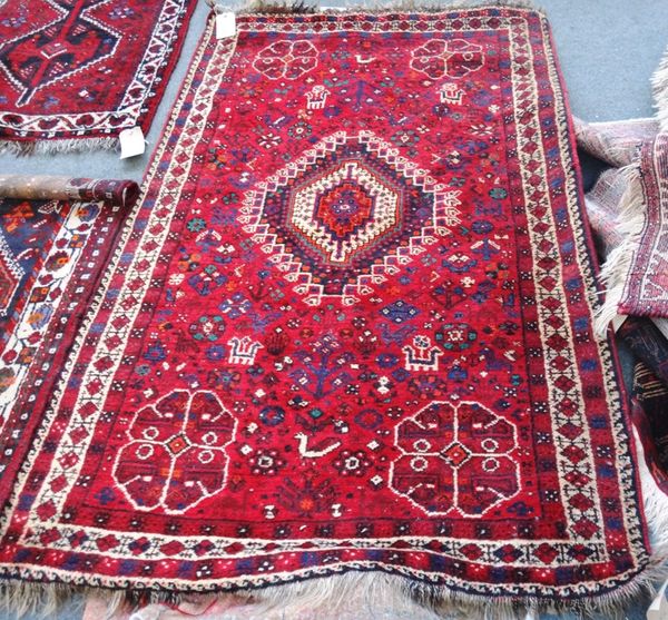 A Shiraz rug, South Persian, the madder field with a central medallion and four corner flowerheads, all with floral motifs and animals, an ivory borde