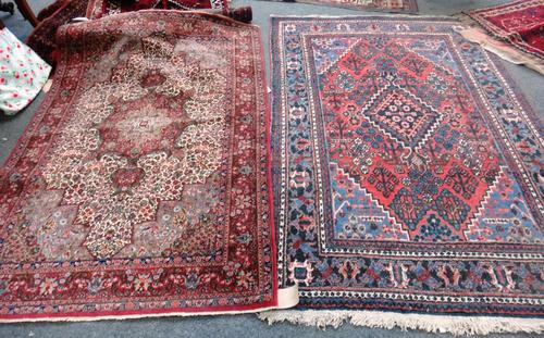 An Indian rug, the ivory field with a madder medallion and indigo spandrels, all with intricate floral sprays, a madder palmette and leaf border, 192c