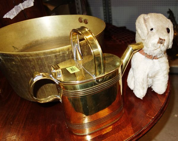 A brass watering can and an early 20th century toy dog. (2)