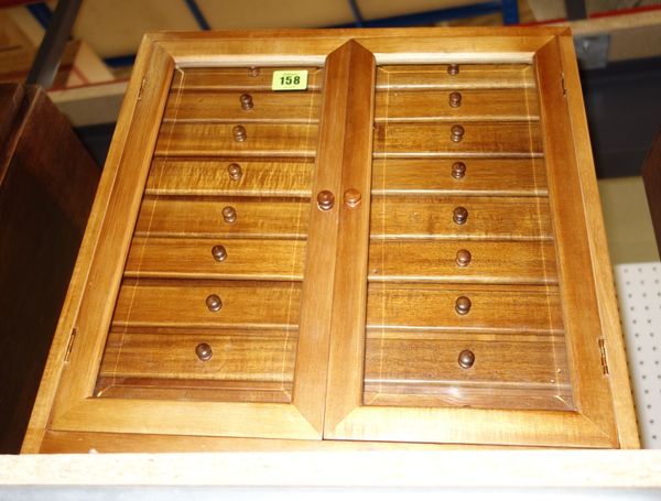A miniature hardwood collectors chest with pair of doors enclosing eighteen drawers.