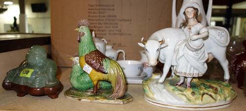 A green hardstone figure of Buddha on a stand, together with an Oriental model of chickens and a Staffordshire model of a cow and girl. (3)