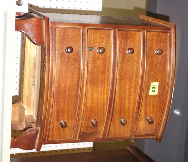 A pair of hardwood bow-front four drawer table top chest. (2)
