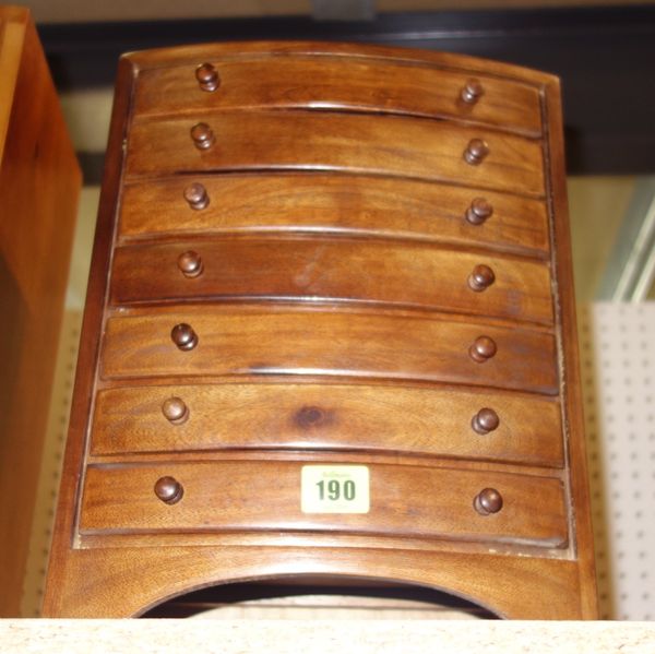 A miniature hardwood bowfront seven drawer table top chest.
