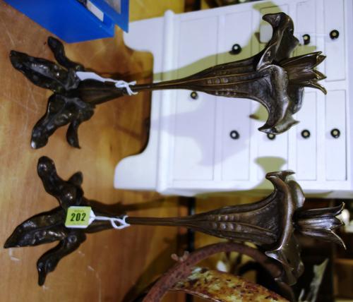 A pair of bronze candlesticks modelled as an orchid flower on a leaf and bud base, 35cm high.