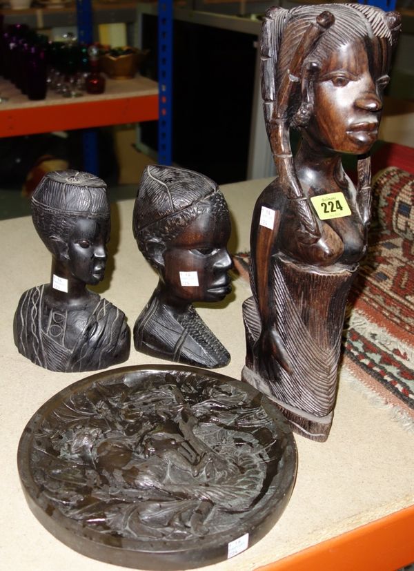 A group of three African carved hardwood figures together with a circular resin plaque depicting a lemur (4).