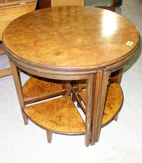 A nest of walnut tables, circa 1930, the circular main table with four quadrant tables, 60cm diameter.