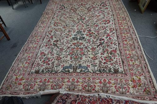 An Indian Carpet, the ivory field with floral sprays and birds, 300cm x 224cm.