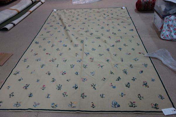 A needlework carpet, the cream field with small single sprays, 274cm x 192cm.