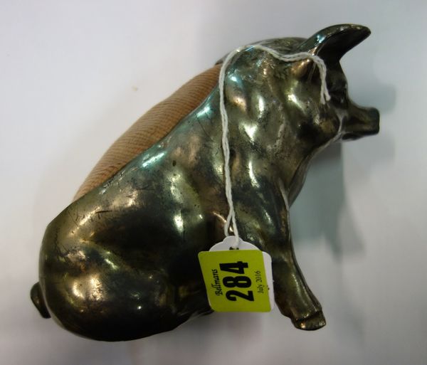 A silver plated spelter pin cushion modelled as a large seated pig, 11cm high.