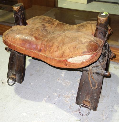 A hardwood and leather camel saddle.