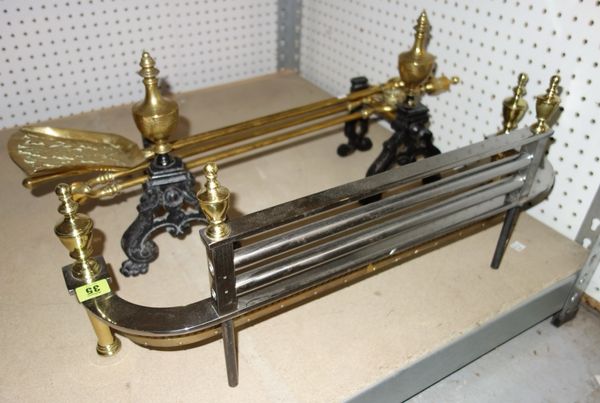 A group of metalware fireside items including a small brass and steel fender, fire tools and dogs. (qty)