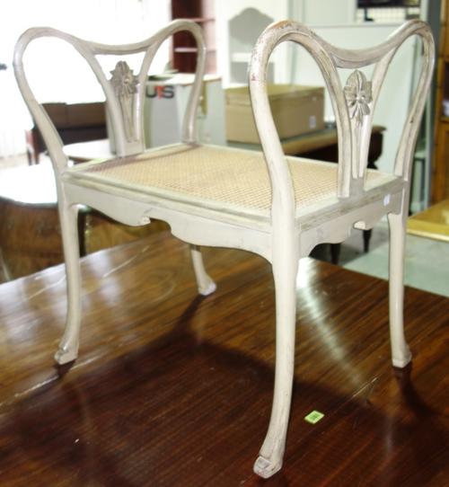 A green painted stool with cane top, 60 cm wide.