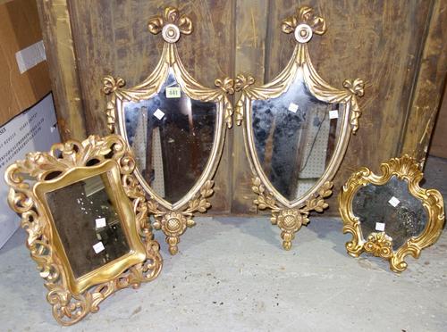 A pair of shield shape gilt mirrors and two further small gilt mirrors (4).