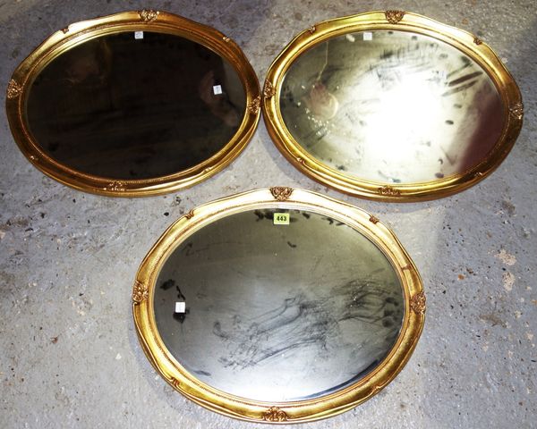 A set of three 20th century oval gilt mirrors, 57 cm wide (3).