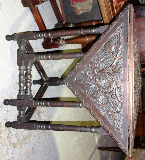 A carved oak drop flap corner table, 67cm wide.