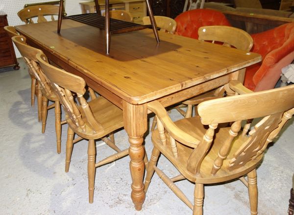 A 20th century rectangular pine dining table on turned supports, 214cm wide.