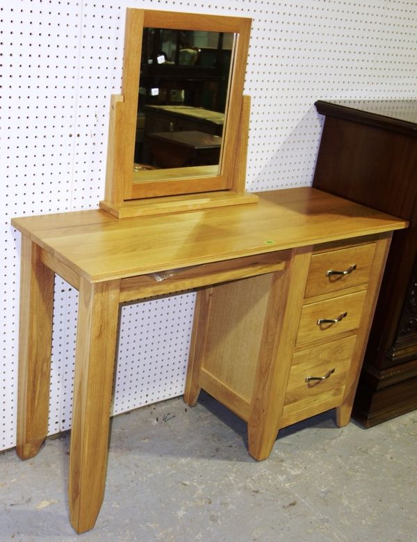 A 20th century oak desk with three drawers, 115cm wide and a swing mirror. (2)