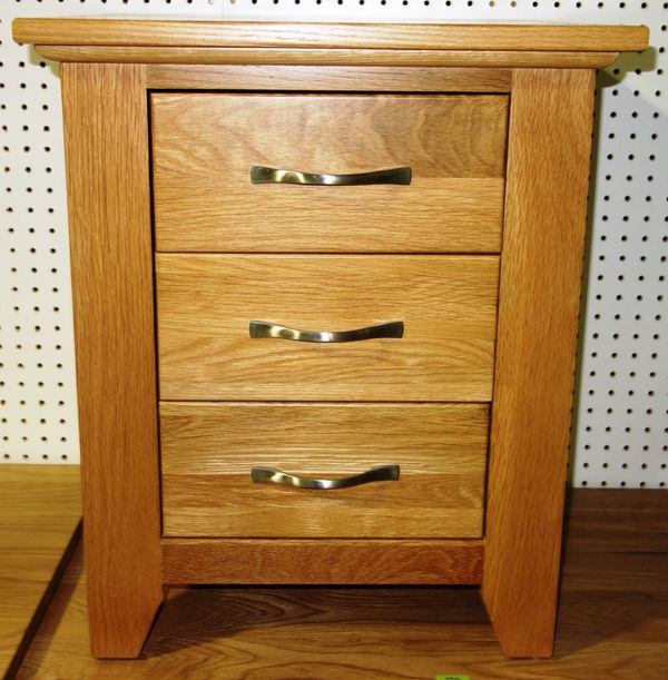 A 20th century oak three drawer bedside chest, 56cm wide.