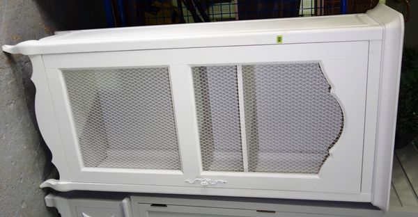 A 20th century French style white painted side cupboard with chicken wire panelled door, 88 cm wide.